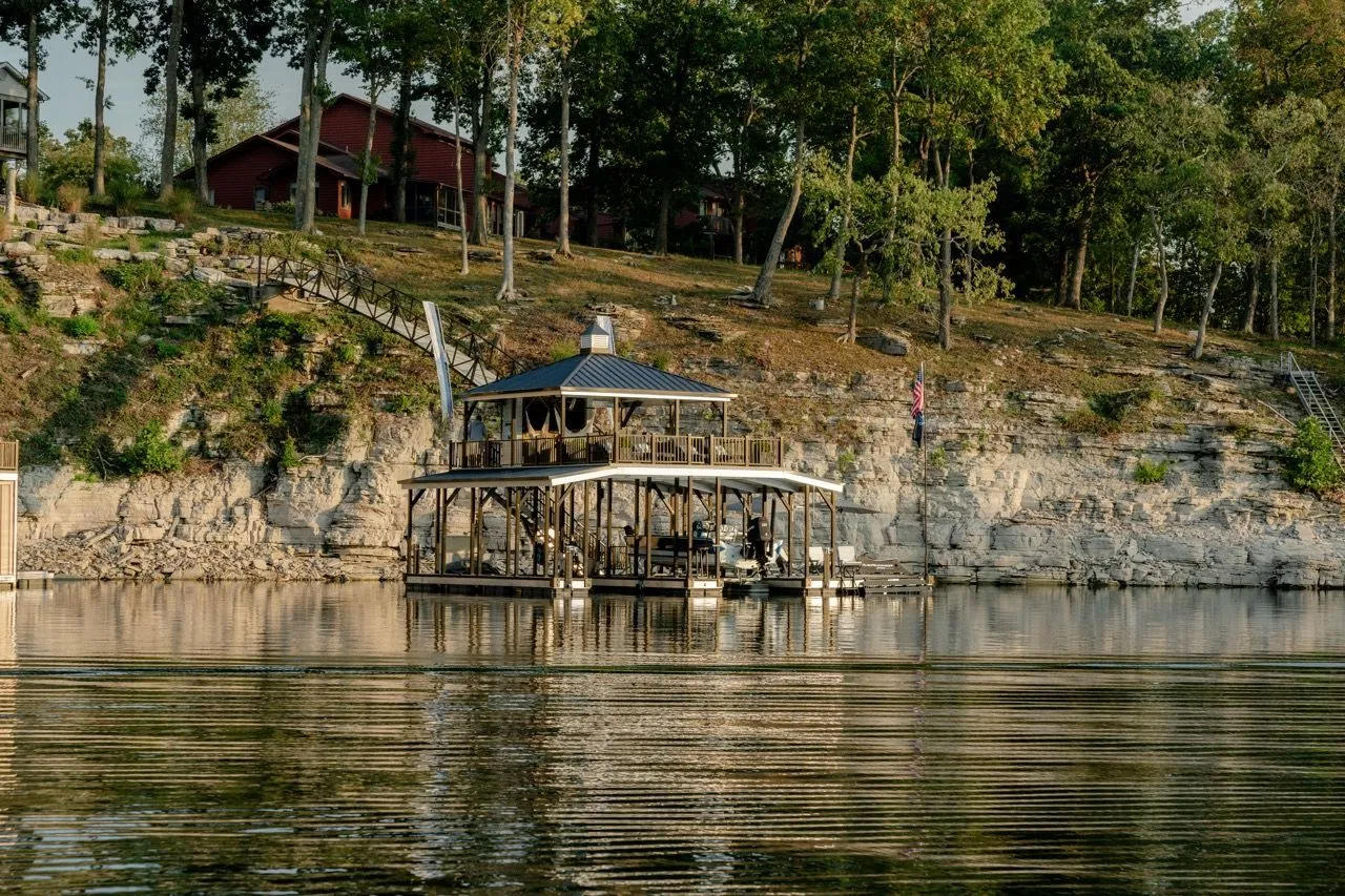 A dock and boat lift on a wooded lake shoreline