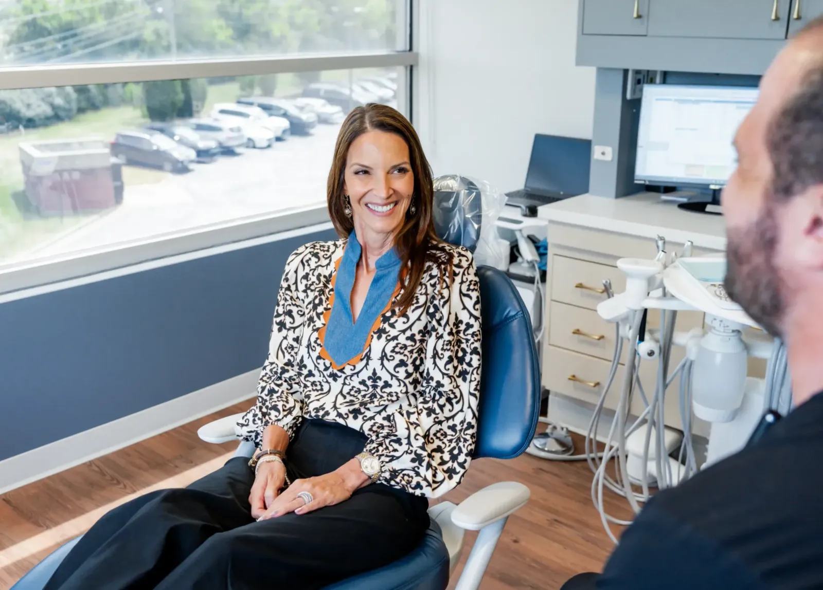 A smiling patient seated in a dental chair at Bluegrass Periodontics