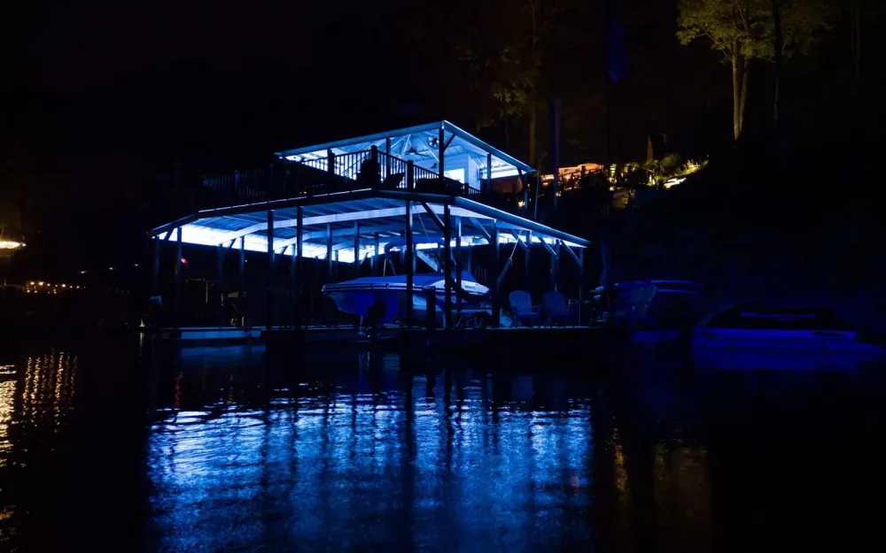 A Dock Solutions boathouse lit blue at night