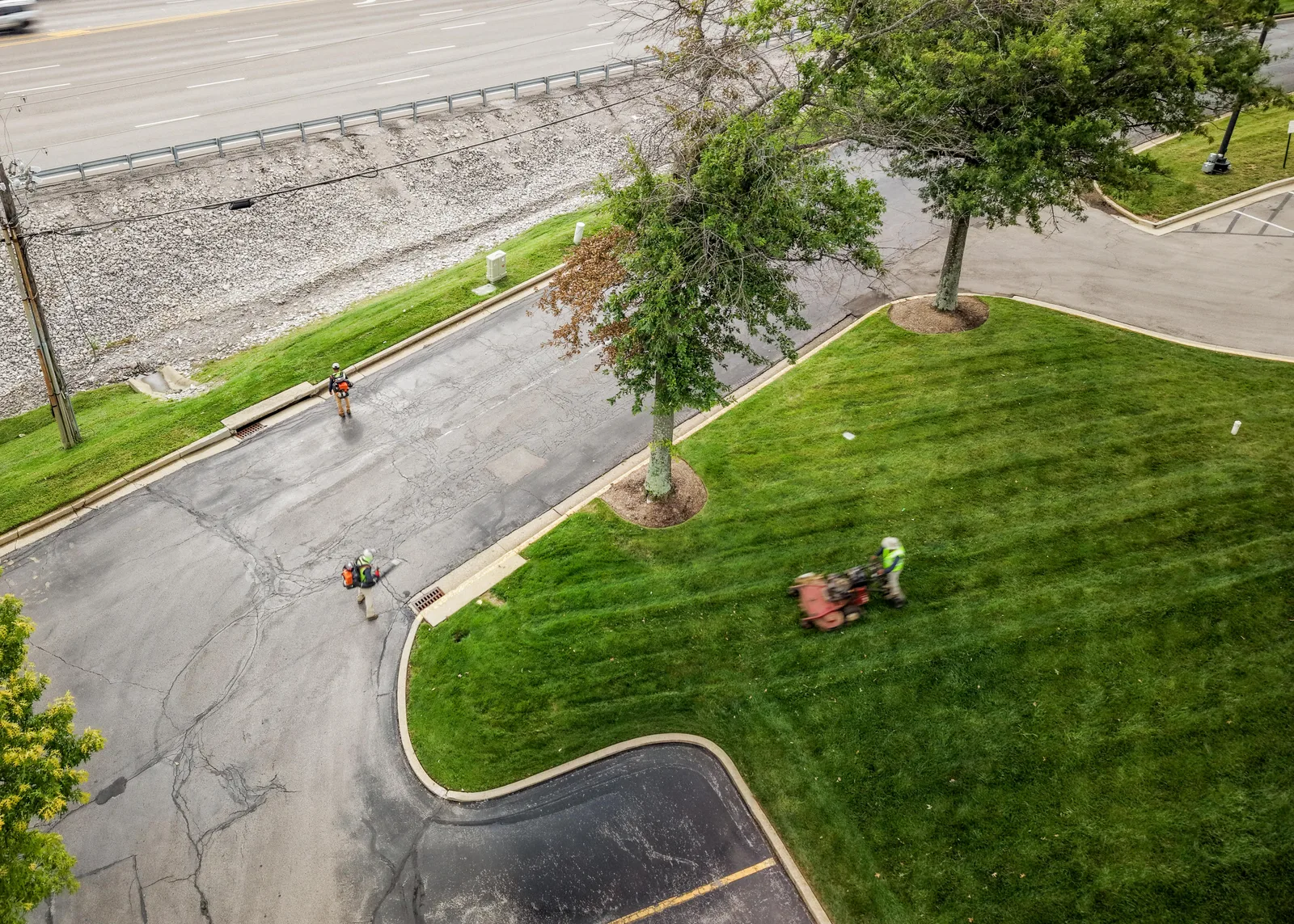 Drone view of a Green Solutions crew mowing and clearing a commercial property