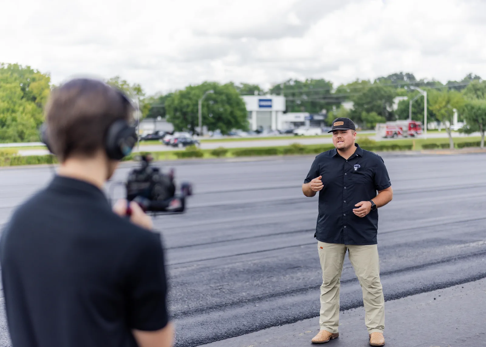 A Housetop videographer filming an APM Paving interview on a freshly paved lot